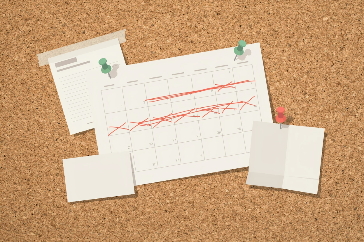 A calendar pinned to a corkboard with a run of days crossed out in red, beside a form and blank notes